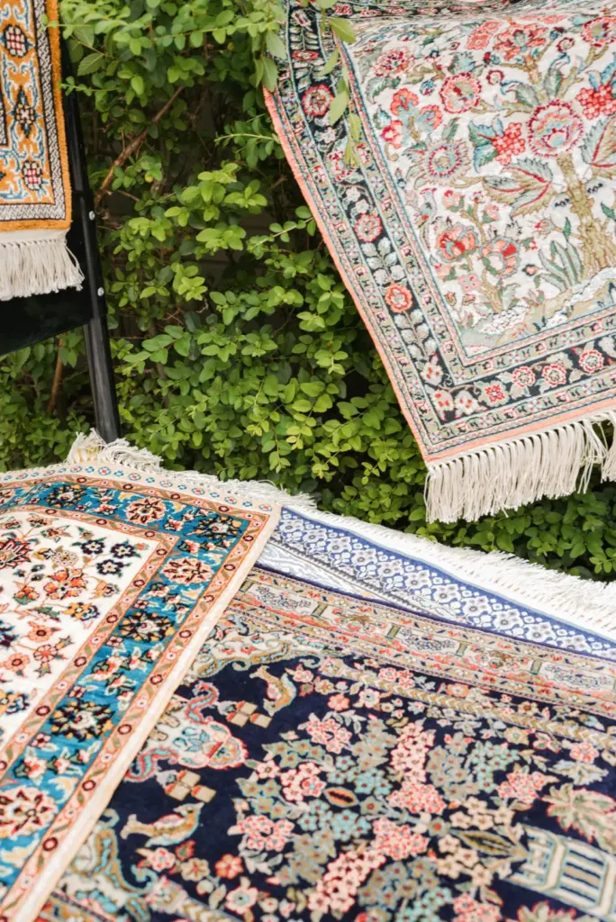 Handmade silk rugs displayed in different colors and designs
