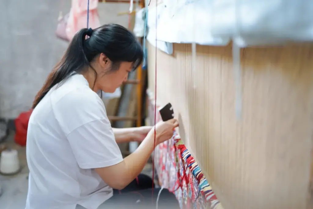 YILONG artisan hand knotting a silk rug on a traditional loom