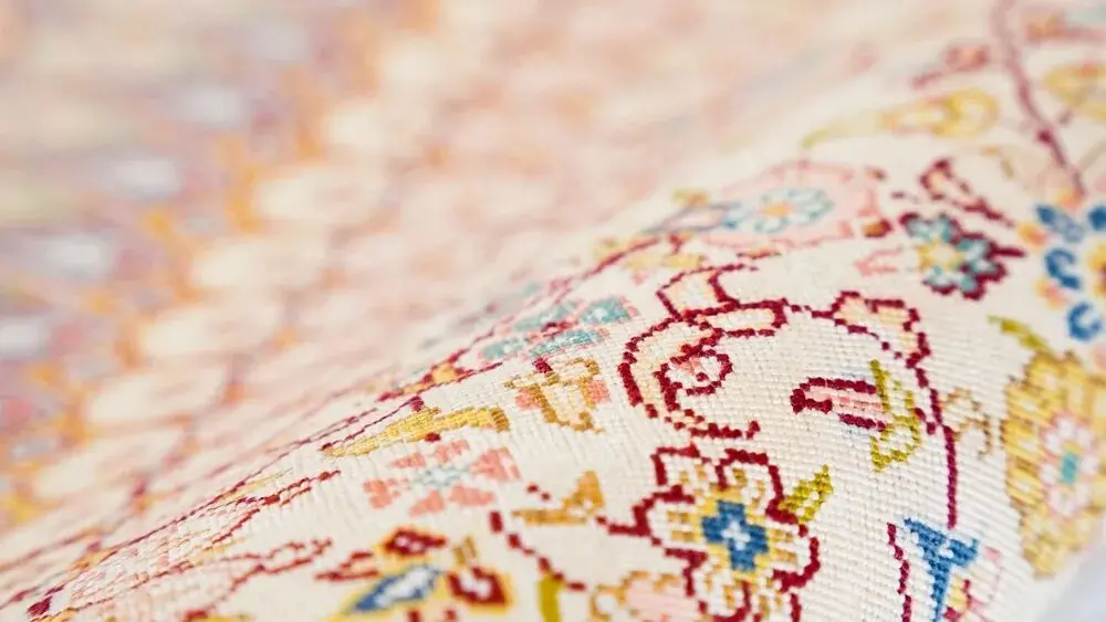 Close-up of fine floral details in a hand-knotted silk rug