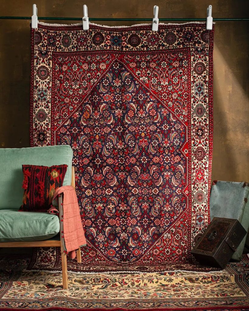 A richly patterned rug displayed in a layered sitting-room setting