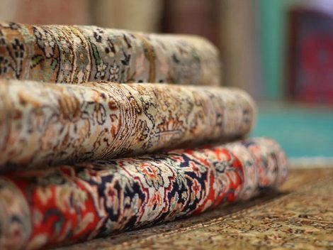 Close-up of several rolled patterned rugs